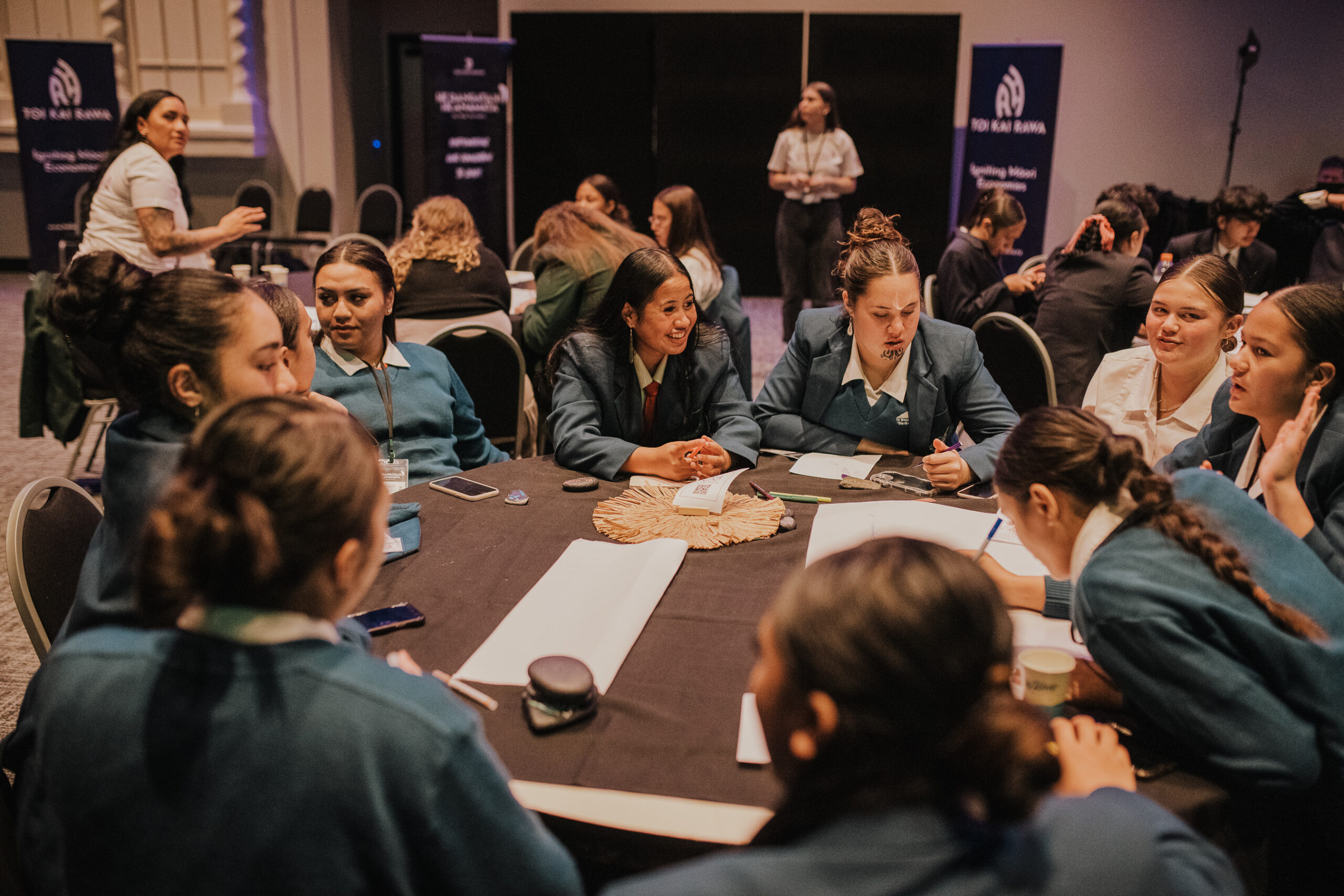 Large table of students discussing at Toi Kai Rawa conference